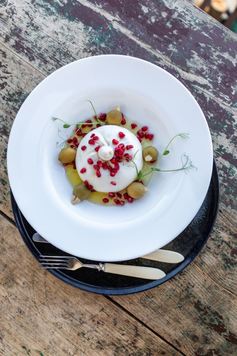 Burrata servirana na rustic stolu sa priborom