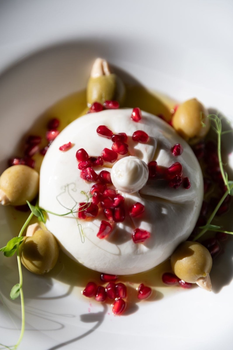 Burrata sir presečena na pola, prikazuje kremasto unutrašnje punjenje